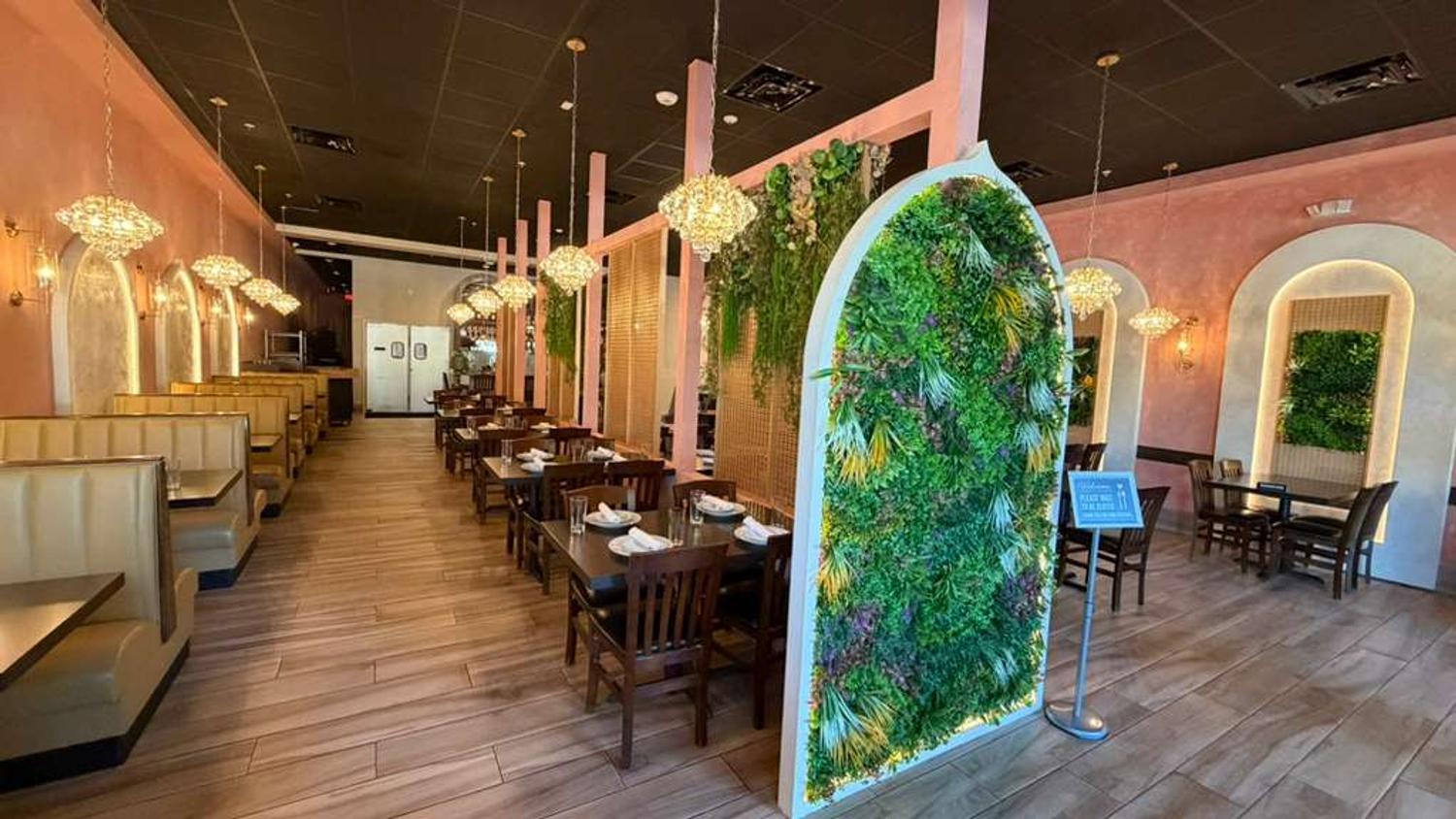 Dining room with living green wall, booths and crystal chandeliers